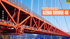 an orange bridge with the words walking tour in front of it and mountains behind it