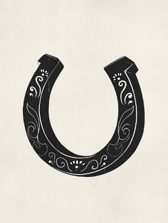 a black and white drawing of a horseshoe with floral designs on the side, against a light gray background