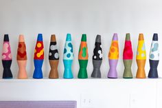 a row of colorful wooden crayons sitting on top of a white shelf