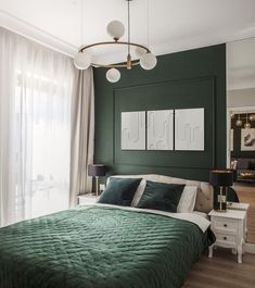 a bedroom with dark green walls and white furniture in the corner, along with two lamps on either side of the bed