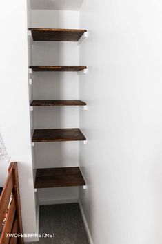 an empty closet with shelving in the corner