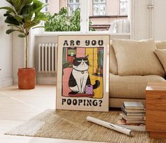 a cat is sitting on the floor next to a poster that says are you pooping?