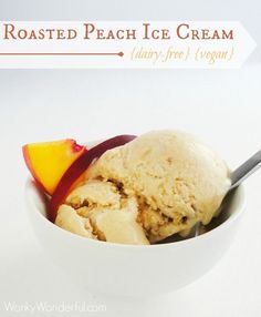 two scoops of ice cream in a white bowl with peaches on the side