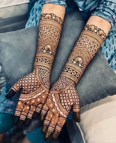 two hands with henna tattoos on them