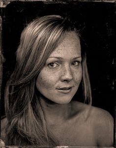 a black and white photo of a woman with freckled hair