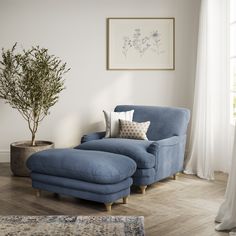 a blue chaise lounge chair and ottoman in a living room