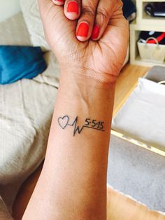 a woman's arm with a tattoo on it that says love and is in the shape of a heart