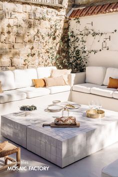 a living room with white couches and tables in the middle of an outdoor space