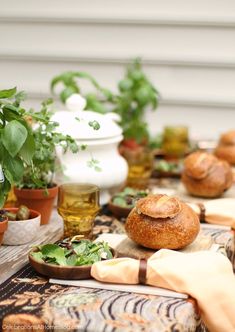 a table topped with bread and potted plants