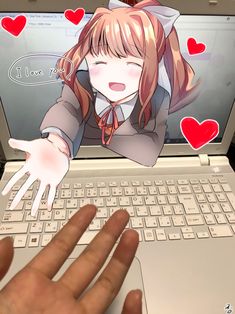 a hand is touching the keyboard of an open laptop computer, with hearts on it