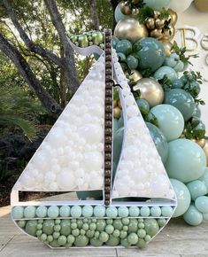 a sailboat made out of balloons sitting next to a tree