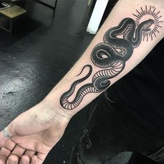 a black and white snake tattoo on the arm