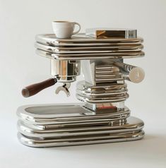 an espresso machine sitting on top of a white table next to a cup