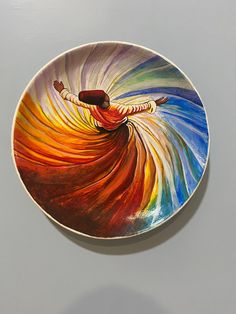 a plate with a painting on it that looks like a woman's body in motion