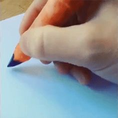 a person is writing on a piece of paper with a pencil in their left hand