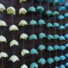 several paper umbrellas are hanging on a wall