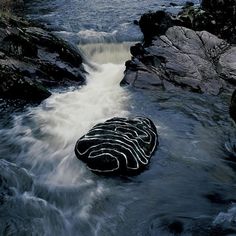 there is a large rock in the middle of some water that is flowing over it