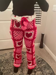 a woman's leggings made out of pink crochet with hearts