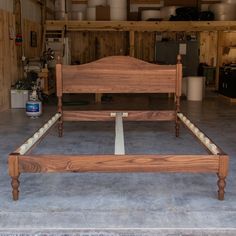 a wooden bed frame sitting on top of a cement floor