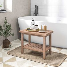 a wooden table sitting in front of a bath tub next to a potted plant