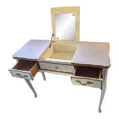 an antique white dressing table with mirror and drawers