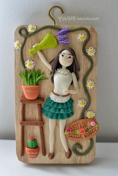 a wooden plaque with a woman holding a potted plant in it's hand