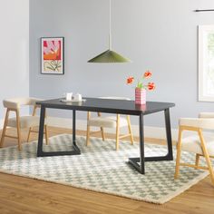 a dining room table with chairs and a rug on the floor in front of it