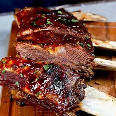 ribs with bbq sauce sitting on top of a cutting board