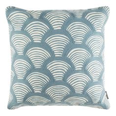 a blue and white pillow with scallops on the front, sitting on a white background