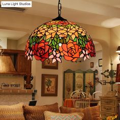 a living room filled with furniture and a large stained glass light hanging from the ceiling