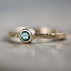 a gold ring with a green stone in it