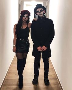 two people dressed up in costumes standing next to each other on a long hallway way