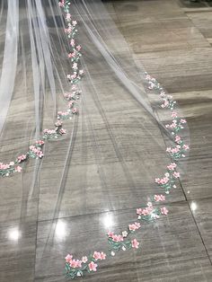 a wedding veil with pink flowers on it