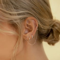 a close up of a woman's ear with two piercings on the side