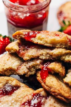 strawberry shortcakes stacked on top of each other next to a jar of jelly