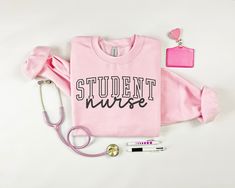 a pink shirt with the words student nurse next to it and a stethoscope