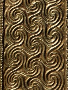 an intricately designed metal panel with wavy designs on it's sides, in gold