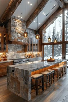 a large kitchen with stone counter tops and an island in front of a window that looks out onto the snow covered mountains