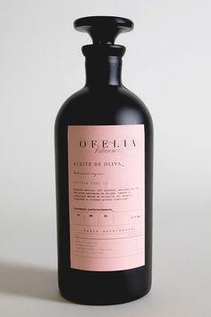 a black bottle with a pink label on it