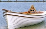 a woman is sitting in a small boat on the water