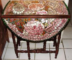 an old wooden table with mosaic tiles on it's top and legs, along with a tile floor