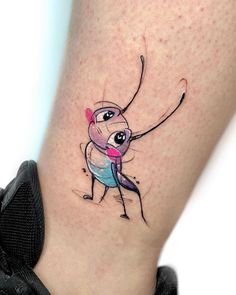 a small tattoo on the leg of a person with a pink and blue ballerina