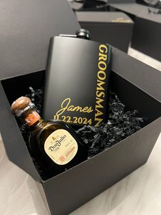 a flask bottle in a black box with some cigars on the table next to it