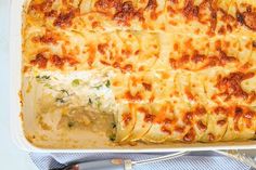 a casserole dish with cheese and spinach in it on a blue cloth