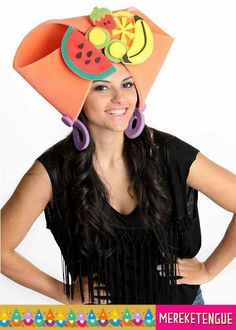 a woman wearing an orange hat with fruit decorations on it's head and purple hoop earrings