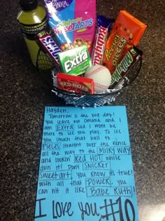 a basket filled with candy and snacks next to a note