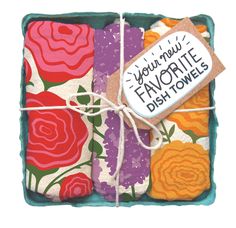 three colorful flowered dish towels tied up in a box with a tag that says, you're new favorite dish towels