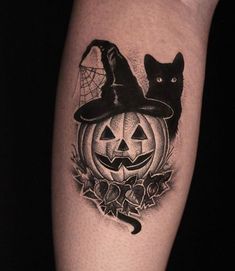 a black cat wearing a witches hat on top of a pumpkin