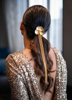 a woman with long hair wearing a gold dress and a golden flower in her hair