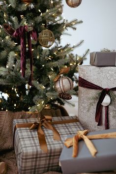 presents under the christmas tree are wrapped in brown and white paper, with gold ribbon